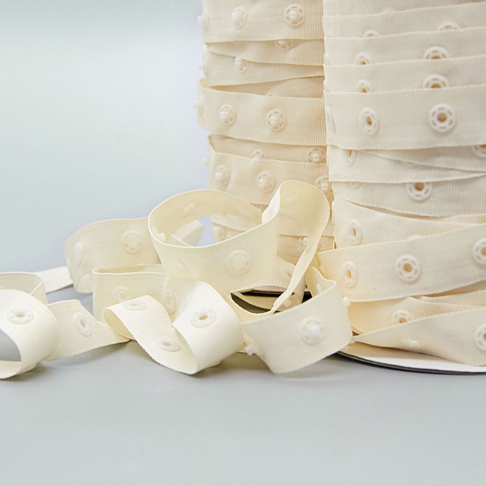 Кнопки пластиковые на тесьме (кн. ⌀ 7мм, тесьма 18 мм, шаг 1.7 см), цв.молочный, 45.7м