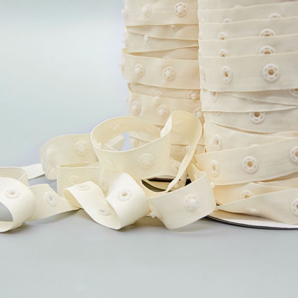 Кнопки пластиковые на тесьме (кн. ⌀ 7мм, тесьма 18 мм, шаг 1.7 см), цв.молочный, 45.7м